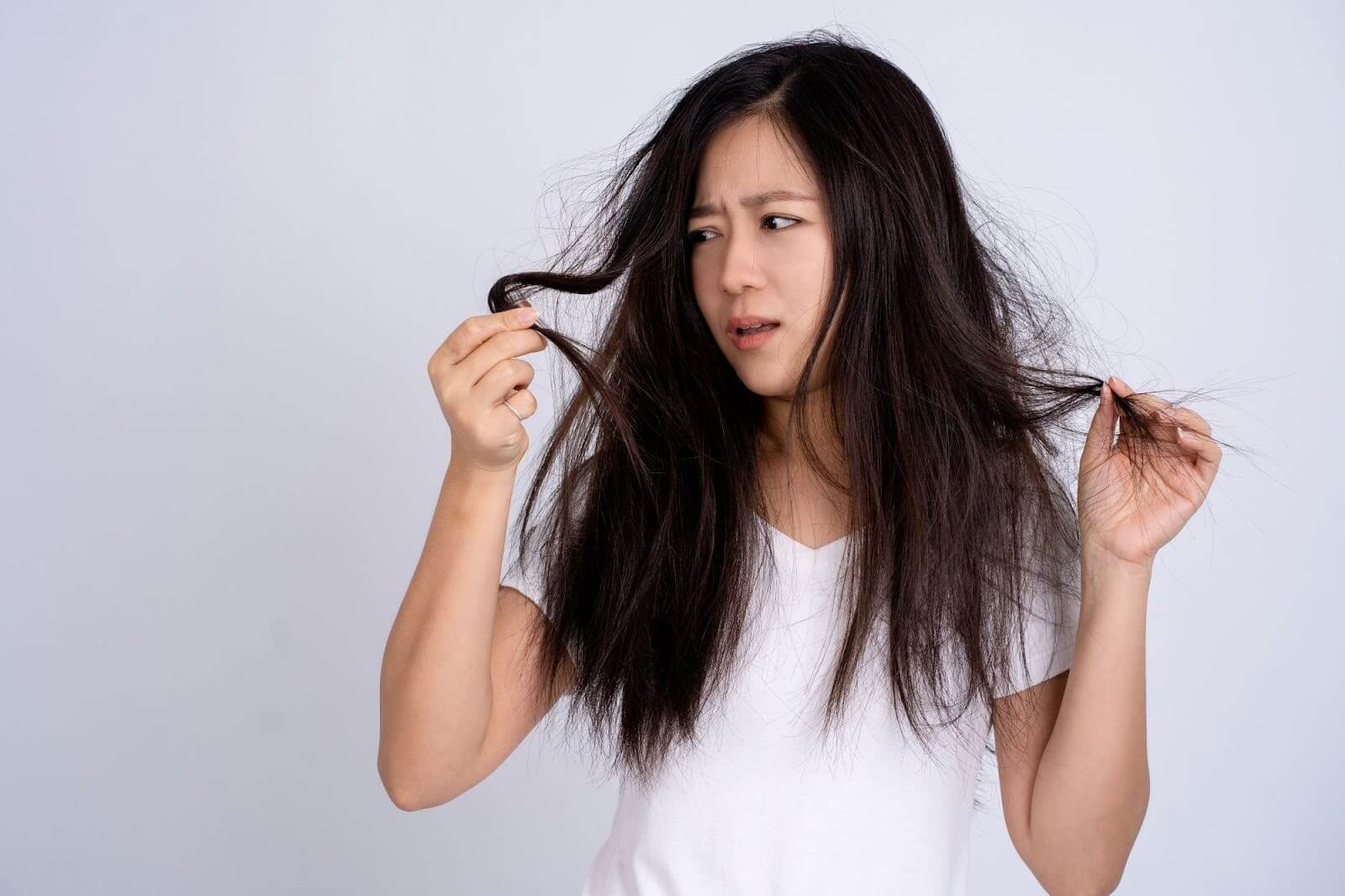 A woman looking at her hair. A woman looking at her hair.